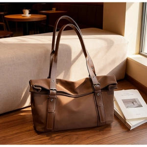 Détail d'un grand sac cabas marron sur parquet avec un éclairage naturel chaleureux