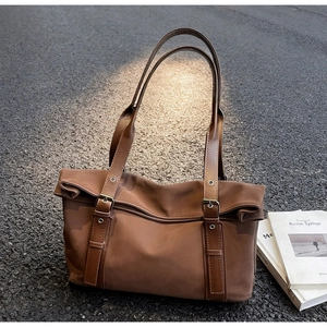 Vue détaillée d'un sac cabas en nylon marron avec sangles en cuir sur route texturée