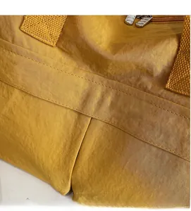 Close-up of waterproof ginger yellow nylon fabric with durable metal dual zippers