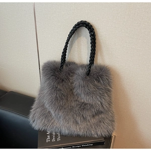 Detail showing the gray faux fur texture and black woven handles of the large tote bag