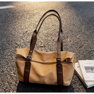 Détail de ce sac fourre-tout en toile kaki avec anses en cuir brun et boucles en argent