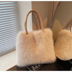 Close-up of fluffy plush tote bag featuring beige faux fur and woven leather handle detail