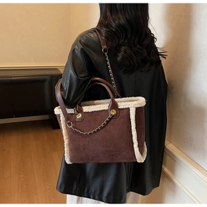 Brown faux suede tote with fur trim and gold chain detail on model shoulder