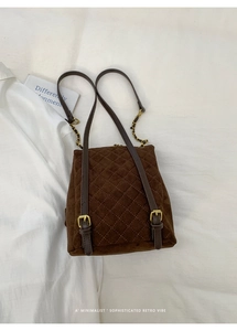 Close-up of brown quilted faux suede backpack with gold hardware and chain straps