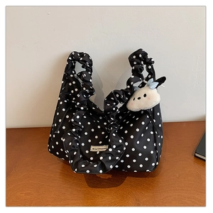 Detailed view of polka dot tote bag with ruffle handle and white plush rabbit charm