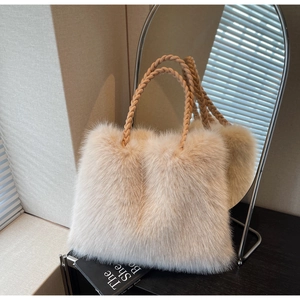 Detail of plush tote bag with faux fur texture and woven handle in cream white color