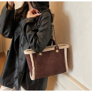 Detail of winter tote bag with brown suede, faux fur trim and gold chain shoulder strap