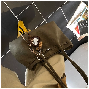 Detail der dunklen Wildleder-Tote Bag mit Herzanhänger und Leopardenmuster-Schleife