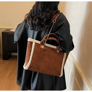Detailed view of plush shearling trim and brown suede texture on a vintage tote bag