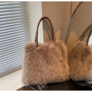 Detailed close-up of woven leather handles and soft faux fur texture on a tote bag
