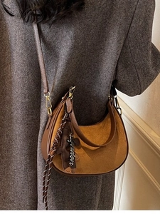 Sac hobo marron en daim avec pendentif lettre London porté par un mannequin