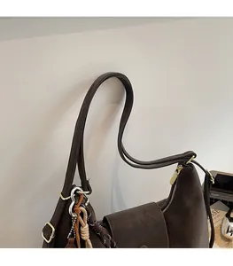 Détail de la bandoulière confortable et texture en cuir marron foncé du sac hobo