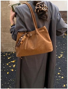 Detailansicht der braunen Wildledershopper mit Leoparden-Anhänger und Metallschnalle