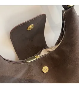 Vue détaillée du sac en daim marron foncé avec boucle magnétique et fermeture dorée