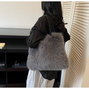 Detail view of the soft grey faux fur texture and black woven strap on the large tote bag