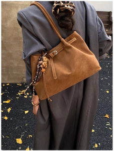 Nahaufnahme braune Wildleder-Einkaufstasche mit Leoparden-Quastenanhänger und mattem Finish