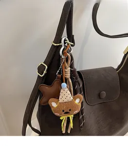 Détail d'un joli bijou de sac ours en peluche avec chapeau à pois et étoile en cuir