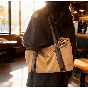 Détail du sac cabas en tissu jaune gingembre avec lanières en cuir brun et boucles