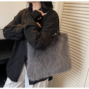 Detail of grey faux fur tote bag with black woven handle shown on model shoulder