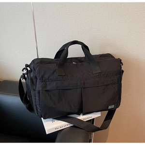 Macro shot of durable black nylon travel bag featuring multiple pockets and carry handles