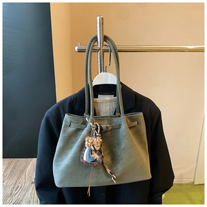Detail der olivgrünen Wildleder-Tote mit Leoparden-Herzanhänger und Kordelzug am Bügel