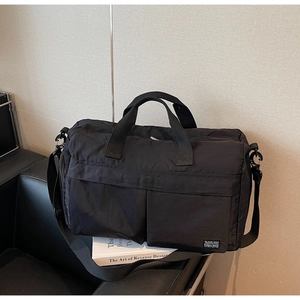 Close-up of black nylon travel bag with multi-pocket design and adjustable strap