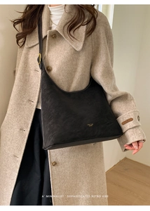 Detail of contrast white stitching and gold logo on black matte vintage hobo shoulder bag