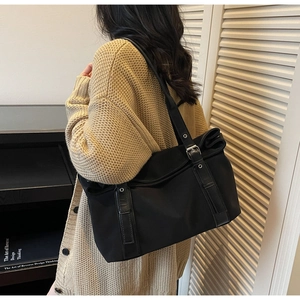 Vue détaillée du grand sac cabas noir en toile avec anses cuir et boucles métal