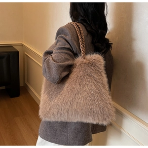 Detail of plush faux fur tote bag with braided handles styled on a shoulder