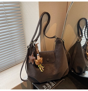 Détail du sac lune marron café montrant la fermeture éclair et l'accessoire ours en peluche
