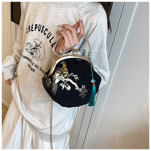 Detail of Chinese style embroidery bag with golden chain and peacock blue silk tassel charm