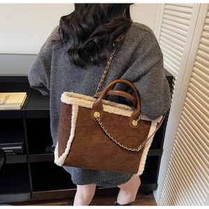 Detail of winter brown suede tote bag with white faux shearling trim and chain strap