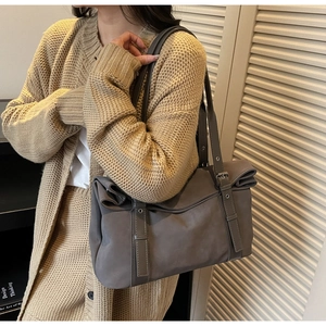 Détail du sac cabas taupe montrant les œillets métalliques et les doubles bandoulières