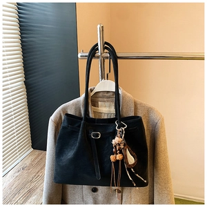 Detail der schwarzen Wildleder-Shopper-Tasche mit Leoparden-Anhänger und Quasten