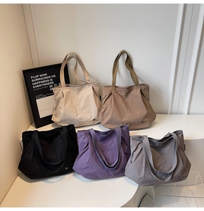 Detail of five multi-color nylon tote bags with wide straps and side pleats