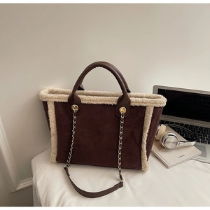 Detail of dark brown faux suede tote bag with plush cream faux fur trim and gold chain strap