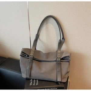 Détail du sac cabas gris mat avec des sangles verticales et des boucles métalliques