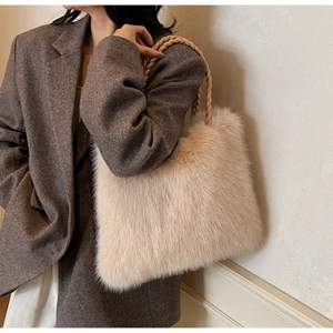 Detail of beige faux fur tote bag with woven handles shown with elegant winter outfit