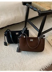 Detail of vintage suede shoulder bags in black and brown with metal twist lock