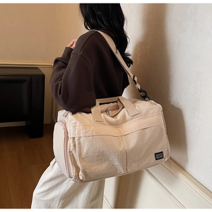 Close-up of beige travel bag with adjustable strap and side pocket for gym use