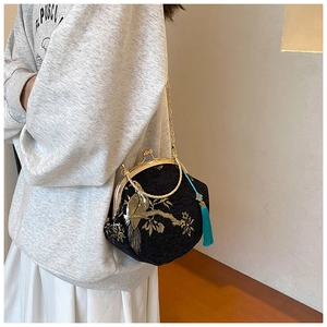 Detail of Chinese style shell bag with gold embroidery and blue tassel accessory