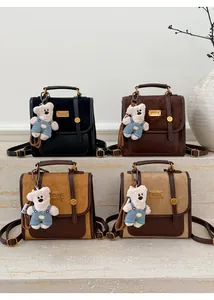 Detailed view of vintage dual-material contrast backpacks in four colors with bear charms