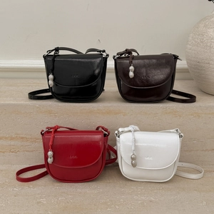 Saddle bags in black, brown, red, and white leather with peanut pendant and metal details