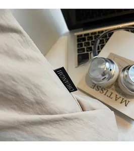 Close-up of CHUANGMI woven label on beige canvas tote bag with aesthetic lifestyle props