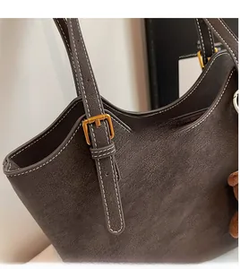 Gros plan du sac cabas rétro avec coutures contrastées et boucle carrée en métal doré