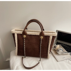 Detail of coffee suede tote bag with white faux fur trim and gold chain shoulder strap