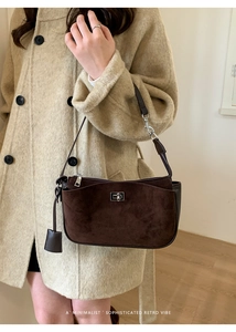 Brown retro suede baguette bag worn by a model in a minimalist home setting