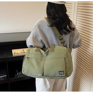 Detail shot of the spacious light green nylon fitness bag with two front zipper pockets