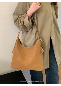 Detailed shot of camel leather hobo bag featuring metal hardware and brand logo