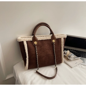 Detail of winter faux suede tote bag with white faux fur trim and metal chain strap